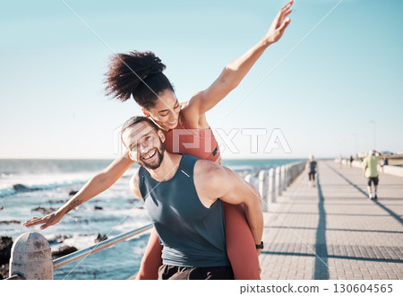 Beach, fitness and couple piggyback in summer enjoying holiday, vacation and quality time on weekend. Love, dating and black man and woman relax after running, exercise workout and training by ocean 130604565