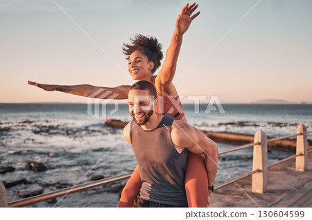 Sunset, relax and couple piggyback by ocean enjoying holiday, vacation and quality time on weekend. Love, freedom and happy black man and woman after exercise, fitness workout and training by sea 130604599