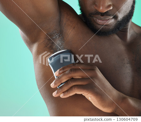 Armpit hygiene and black man with deodorant and self care routine product of people with body zoom in studio. Health, wellness and cosmetic grooming of young person at isolated green background 130604709