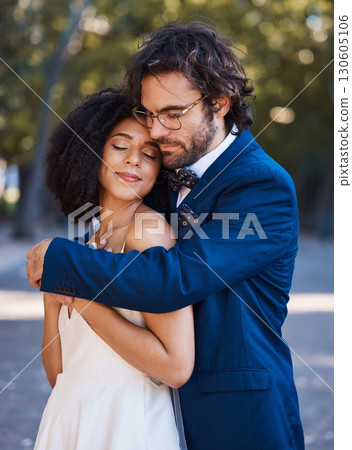 Interracial wedding, black woman and man with hug with smile, happiness or future together. African bride, husband and diversity at outdoor marriage for love, embrace or eye contact in sunshine 130605106