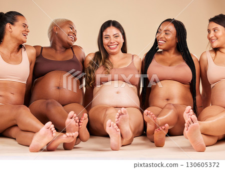 Pregnancy, body and laughing women sitting on studio background floor in relax support, mothers day or diversity. Happy smile, pregnant and bonding friends in underwear for with funny, comic or joke 130605372