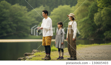 父子倆在湖邊釣魚，母親在一旁注視著他們。露營場景。 130605403