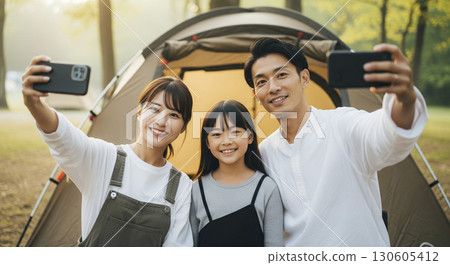 Family taking a selfie in front of a tent Camping Outdoors Family taking a selfie in front of a tent Camping Outdoors 130605412