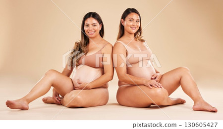 Women, portrait or sitting and pregnancy stomach, tummy growth progress or baby healthcare wellness on studio background. Smile, happy or friends in pregnant underwear for solidarity support or love 130605427