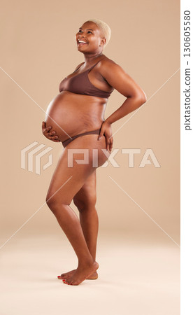 Black woman, laughing or holding pregnant stomach on studio background in body empowerment, love or baby support. Smile, happy and pregnancy model in body underwear or ready for motherhood on mock up 130605580