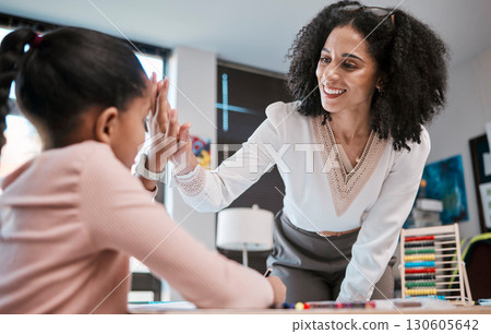 High five, success or teacher in celebration with a student in a classroom with learning development. Goals, education or happy black woman smiles teaching or celebrates a target with a school girl High five, success or teacher in celebration with a student in a classroom with learning development. Goals, education or happy black woman smiles teaching or celebrates a target with a school girl 130605642