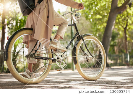 Bicycle, closeup and feet of casual cyclist travel on a bike in a park outdoors in nature for a ride or commuting. Exercise, wellness and lifestyle student cycling as sustainable transport 130605754
