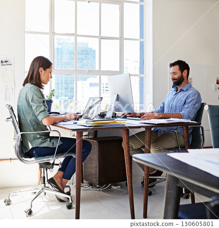 Coworkers, concentration and man and woman in coworking space at creative agency working together on startup project. Teamwork, computer and website, employees or business people at design office. 130605801