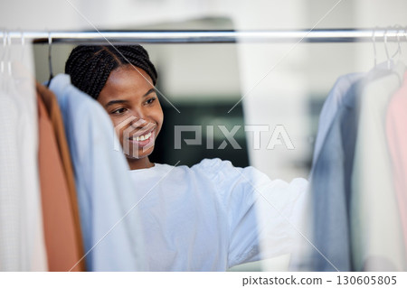 Shopping, fashion and black woman in store with clothes choice on rack for sale, discount and promotion. Retail, designer boutique and happy girl customer with clothing, outfit and wardrobe products 130605805