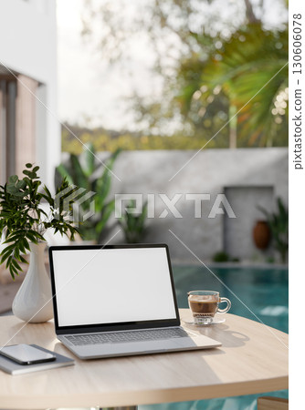 A digital tablet and phone placed next to coffee cup on wooden table beside an empty swimming pool. A digital tablet and phone placed next to coffee cup on wooden table beside an empty swimming pool. 130606078