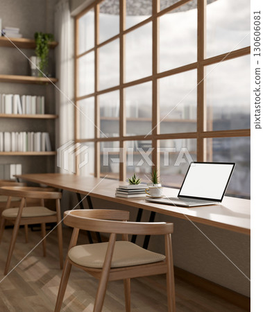 White screen laptop on long table under a glass wall next to large bookshelf. library or study room White screen laptop on long table under a glass wall next to large bookshelf. library or study room 130606081