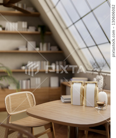 A coffee cup and bean bags on wooden table under roof window in the room with large wall bookshelf. 130606082
