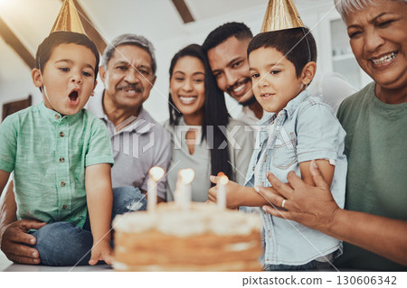 Kid, birthday candles and child with cake at a house at a party with food and celebration. Children, celebrate event and family together in a kitchen with a smile and happiness with parent love 130606342