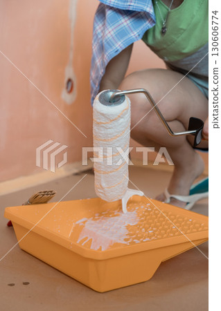 Young Woman Painting Peach Wall with Roller. Home Improvement, Interior Design, Pastel Colors, DIY Project, Fresh Decor, Spring Renovation Young Woman Painting Peach Wall with Roller. Home Improvement, Interior Design, Pastel Colors, DIY Project, Fresh Decor, Spring Renovation 130606774