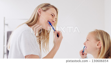 Happy mom, girl child and brushing teeth in bathroom, learning and care with foam for wellness in family house. Toothbrush, mother and daughter with toothpaste, teaching or cleaning mouth for health Happy mom, girl child and brushing teeth in bathroom, learning and care with foam for wellness in family house. Toothbrush, mother and daughter with toothpaste, teaching or cleaning mouth for health 130606854