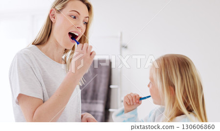 Mom, girl child and brushing teeth in bathroom, learning and learning with foam for wellness in family house. Toothbrush, mother and daughter with toothpaste, teaching and cleaning mouth for health 130606860