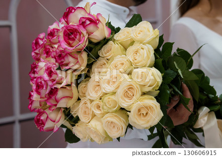 Romantic Wedding Bouquet of Pink and Cream Roses Held by Brides, Ceremony Scene with White Dresses. Romantic Wedding Bouquet of Pink and Cream Roses Held by Brides, Ceremony Scene with White Dresses. 130606915