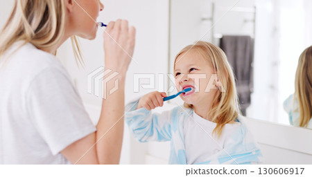 Mom, girl kid and brushing teeth in bathroom, learning and support with foam for wellness in family house. Toothbrush, mother and daughter with toothpaste, teaching and health with cleaning mouth Mom, girl kid and brushing teeth in bathroom, learning and support with foam for wellness in family house. Toothbrush, mother and daughter with toothpaste, teaching and health with cleaning mouth 130606917