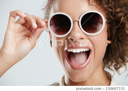 Beauty, sunglasses and face of woman with smile on white background for summer, casual and trendy style. Creative, accessory and zoom of excited girl in studio with cosmetics, makeup and confidence 130607131