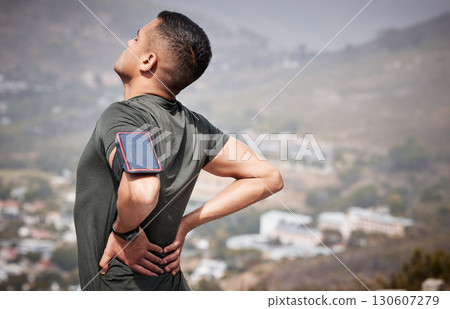 Fitness, pain and man with hands on back, hurt muscle on run with smartphone running tracker. Health, exercise and outdoor workout, runner with injury, tension or painful muscles on marathon training 130607279