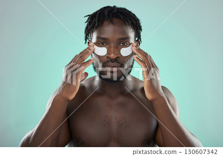 Skincare, eye pads and black man in studio for healthy, cosmetic and natural face routine. Health, wellness and portrait of an African guy with a facial treatment by blue background with mockup space 130607342
