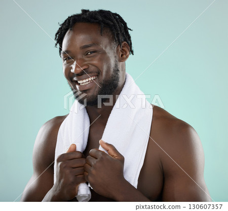 Man, face portrait and skin in studio with towel for hygiene and grooming. Healthy and happy black person on blue background for facial glow, cosmetics and self care with dermatology skincare brand Man, face portrait and skin in studio with towel for hygiene and grooming. Healthy and happy black person on blue background for facial glow, cosmetics and self care with dermatology skincare brand 130607357