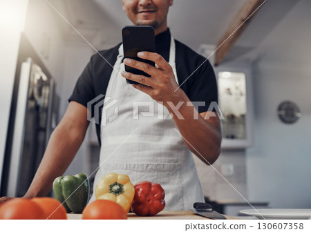 Cooking vegetables, phone and man in kitchen while online with house wifi connection for learning on food blog. Chef person with mobile app for online recipe for home food for vegan or healthy eating 130607358
