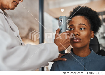 Face, eye exam or black woman consulting doctor for eyesight at optometrist or ophthalmologist. African customer testing vision with hands of optician helping or testing iris or retina visual health Face, eye exam or black woman consulting doctor for eyesight at optometrist or ophthalmologist. African customer testing vision with hands of optician helping or testing iris or retina visual health 130607413