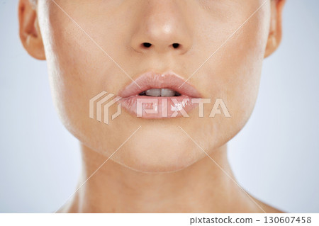 Makeup, lips and beauty of a woman in studio with lipstick for shine and natural glow cosmetics. Face, mouth and skin zoom of aesthetic model person for self care, skincare and facial wellness Makeup, lips and beauty of a woman in studio with lipstick for shine and natural glow cosmetics. Face, mouth and skin zoom of aesthetic model person for self care, skincare and facial wellness 130607458