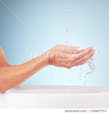 Senior hands, water and wash for clean hygiene, fresh minerals or splash against a studio background. Hand of elderly holding natural liquid for skin hydration, wellness or skincare in sink or basin 130607553