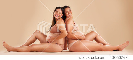 Pregnant woman friends, studio and underwear with smile, sitting and together for support by backdrop. Happy women, pregnancy and solidarity for wellness, care and holding healthy stomach by backdrop Pregnant woman friends, studio and underwear with smile, sitting and together for support by backdrop. Happy women, pregnancy and solidarity for wellness, care and holding healthy stomach by backdrop 130607683