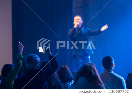 Crowd capturing live performance with smartphones under stage lights Crowd capturing live performance with smartphones under stage lights 130607792