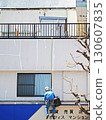 A view of a rooftop fence. One person is working while hanging from it. 130607835