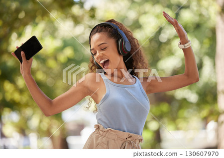 Phone, music and dance with a black woman listening to the radio in the park during summer while feeling free. Freedom, sing and dancing with an attractive young female streaing audio in a garden 130607970