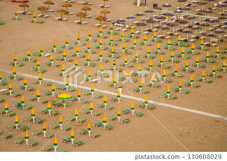 Wide sandy beach with sun loungers and umbrellas view from above. Evening on the Rimini coast 130608029