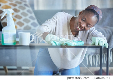 Cleaning, table and black woman with cloth in home for dirt, dust and bacteria on furniture. Happy cleaner, housekeeping and maid wipe surface in living room for routine maintenance, safety and care Cleaning, table and black woman with cloth in home for dirt, dust and bacteria on furniture. Happy cleaner, housekeeping and maid wipe surface in living room for routine maintenance, safety and care 130608047
