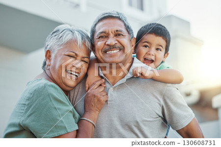 Grandparents, hug and child with smile for happy holiday or weekend break with elderly people at the house. Portrait of grandma and grandpa holding little boy on back for fun playful summer together 130608731