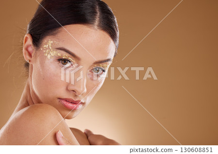 Gold makeup, woman and beauty portrait with model ready for cosmetic, wellness and spa. Brown background, studio and isolated young female person with mock up, cosmetics and glitter eyes alone Gold makeup, woman and beauty portrait with model ready for cosmetic, wellness and spa. Brown background, studio and isolated young female person with mock up, cosmetics and glitter eyes alone 130608851