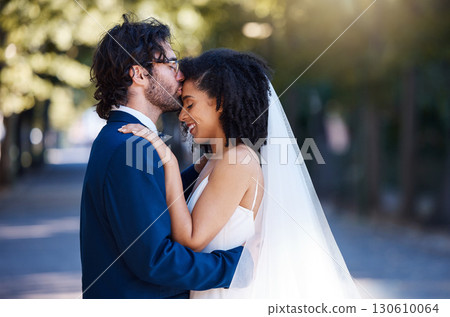 Wedding, happy and kiss of couple with hug at romantic outdoor marriage event celebration together. Partnership, commitment and trust embrace of interracial bride and groom with excited smile. 130610064