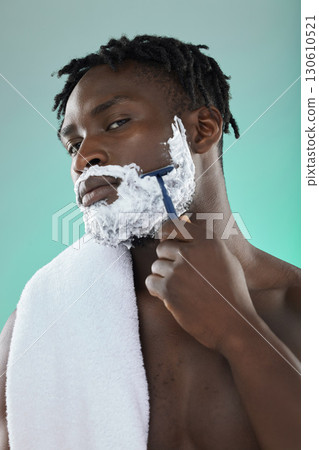 Black man, studio and cream for shaving, beauty or razor for facial, cosmetics or skincare by blue background. African gen z model, hair removal foam and shave for aesthetic, cleaning and self care 130610521
