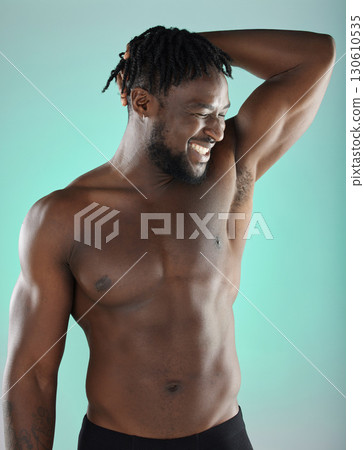 Armpit, bicep and happy man with skincare hygiene or grooming isolated against a studio background. Natural, cosmetics and body care for healthy skin by a young, confident and African model 130610535