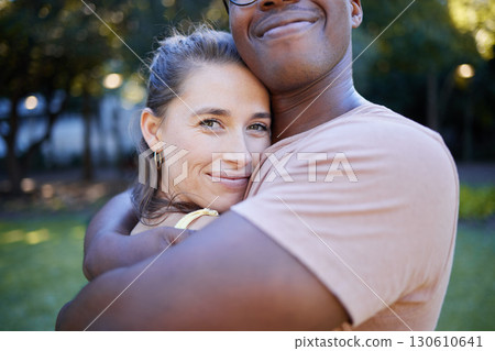 Interracial relationship hug, park and woman with smile, care and love with black man, reunion and happiness. Multicultural embrace, happy couple and diversity on nature adventure, bonding and spring 130610641