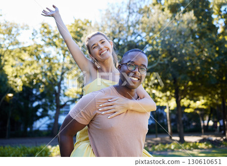 Interracial couple, piggy back and portrait of people with love, care and smile on summer park date. Happiness, hug and young man and woman outdoor on adventure together happy with bonding in nature 130610651