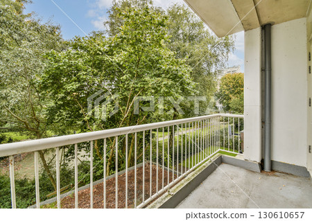 A spacious balcony offers a serene view of lush green trees and a well-kept garden, providing a perfect spot for relaxation and enjoyment of nature. A spacious balcony offers a serene view of lush green trees and a well-kept garden, providing a perfect spot for relaxation and enjoyment of nature. 130610657