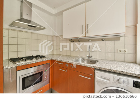 A modern kitchen featuring sleek cabinetry, stainless steel appliances, and a compact layout, perfect for efficient cooking and entertaining. A modern kitchen featuring sleek cabinetry, stainless steel appliances, and a compact layout, perfect for efficient cooking and entertaining. 130610666
