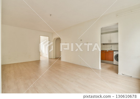 An empty room showcasing a minimalist design, featuring light-colored walls and wooden flooring, ideal for various interior styles or decoration ideas. 130610678