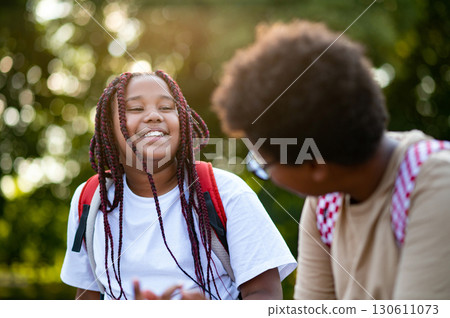 Teens sitting at the playground after school and talking Teens sitting at the playground after school and talking 130611073