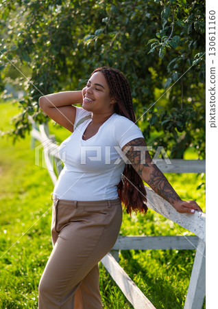Happy woman on summer stroll surrounded by trees and sunshine 130611160