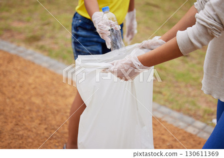 Charity, earth day and volunteer cleaning trash for climate change outdoors at park to recycle for the environment. Planet, sustainability and community activists to pickup pollution, trash or litter Charity, earth day and volunteer cleaning trash for climate change outdoors at park to recycle for the environment. Planet, sustainability and community activists to pickup pollution, trash or litter 130611369