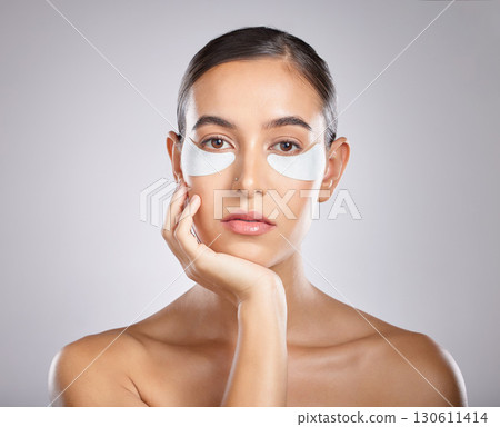 Beauty, eye patch and portrait of woman with skincare product for self care, anti aging and wellness. Facial healthcare, spa salon and aesthetic model face with makeup cosmetics on studio background Beauty, eye patch and portrait of woman with skincare product for self care, anti aging and wellness. Facial healthcare, spa salon and aesthetic model face with makeup cosmetics on studio background 130611414